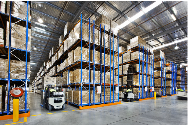 Forklift working an aisle of double deep pallet racking stacked with boxed goods