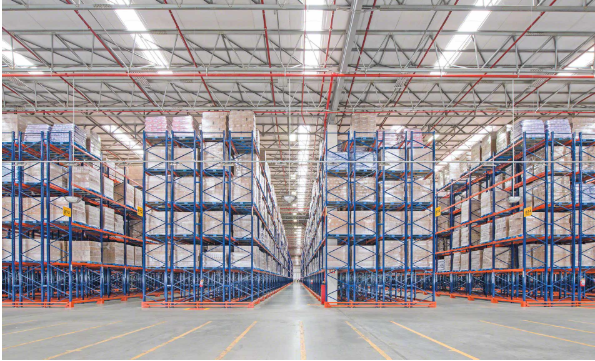 Long rows of double deep pallet racking loaded with wrapped pallets in a large warehouse