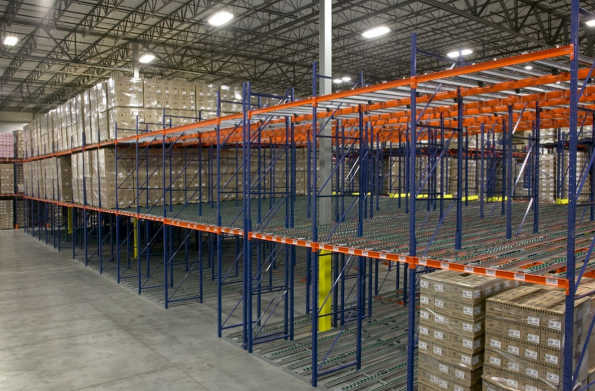 Forklift loading a pallet into the rear of a pallet flow racking lane