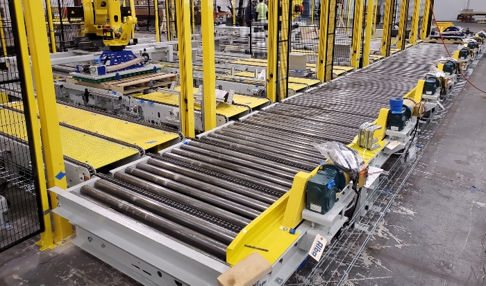 Pallet conveyor system moving palletized loads through a warehouse